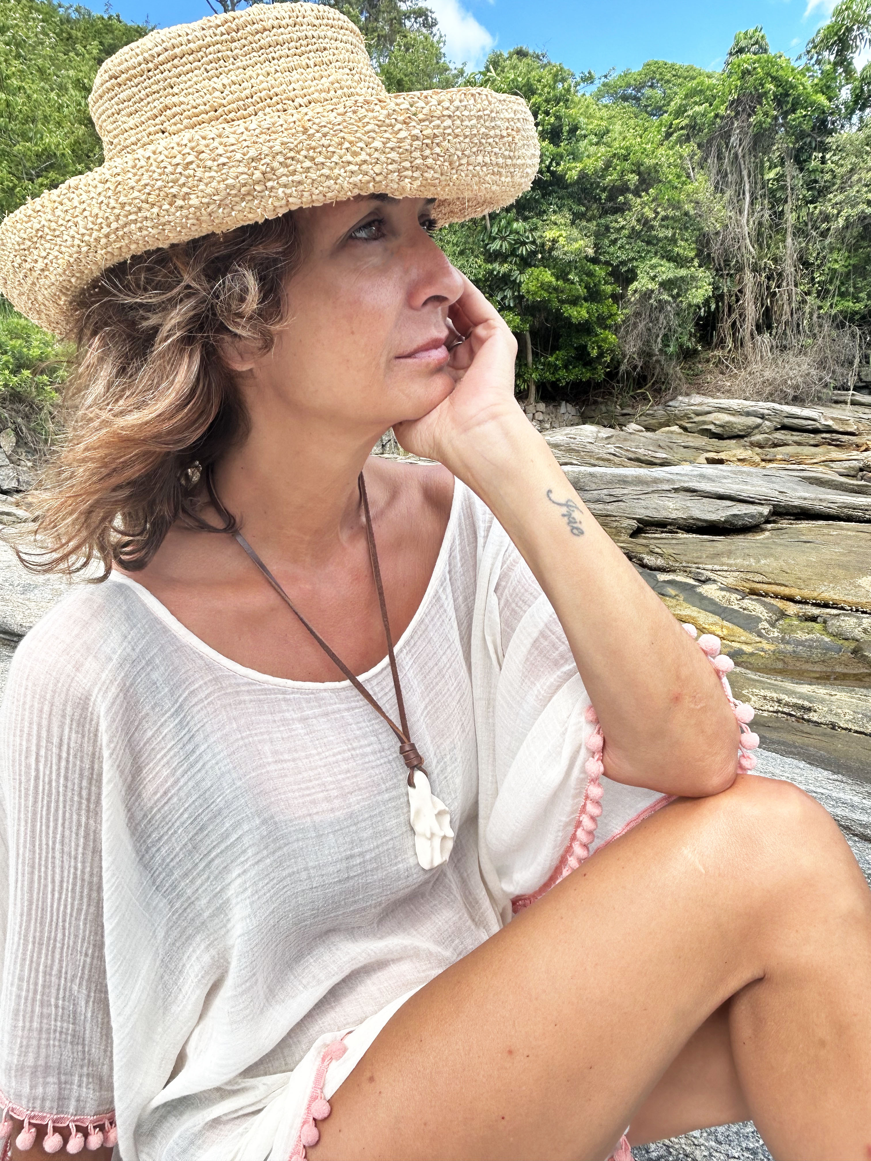Portrait wearing ceramic pendant in seaside landscape